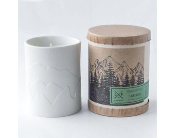 White porcelain candle with mountains that glow while the candle burns. Fragrances inspired by the outdoors.