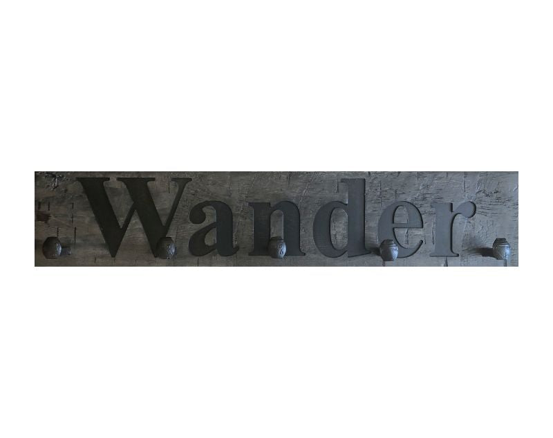 Wood wall coat rack with the words Wander, in burned letters. Reclaimed wood and railroad spikes as hooks.