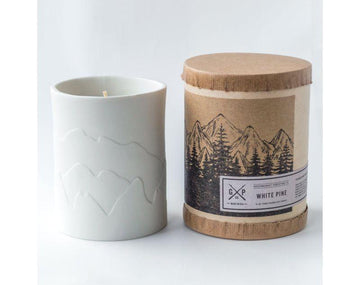 White porcelain candle with mountains that glow while the candle burns. Fragrances inspired by the outdoors.